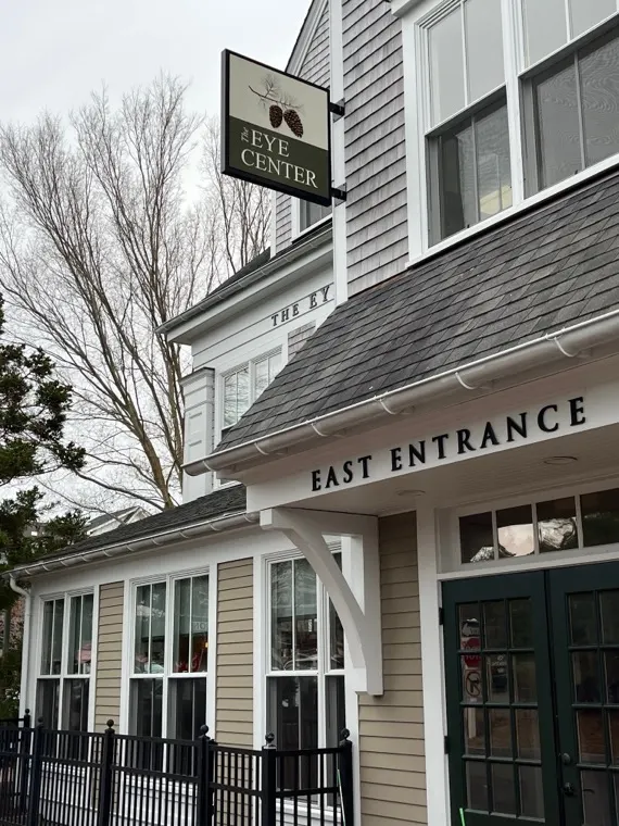 The Eye Center east entrance and hanging sign with the pine-cone logo